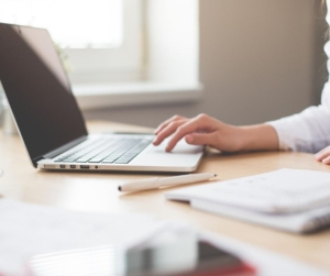 Woman sitting at desk working on laptop.