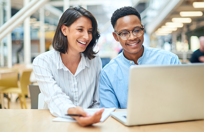 Shot of a young businessman and businesswoman using a laptop in a modern office.