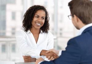 smiling woman shaking the hand of a man she just interviewed with